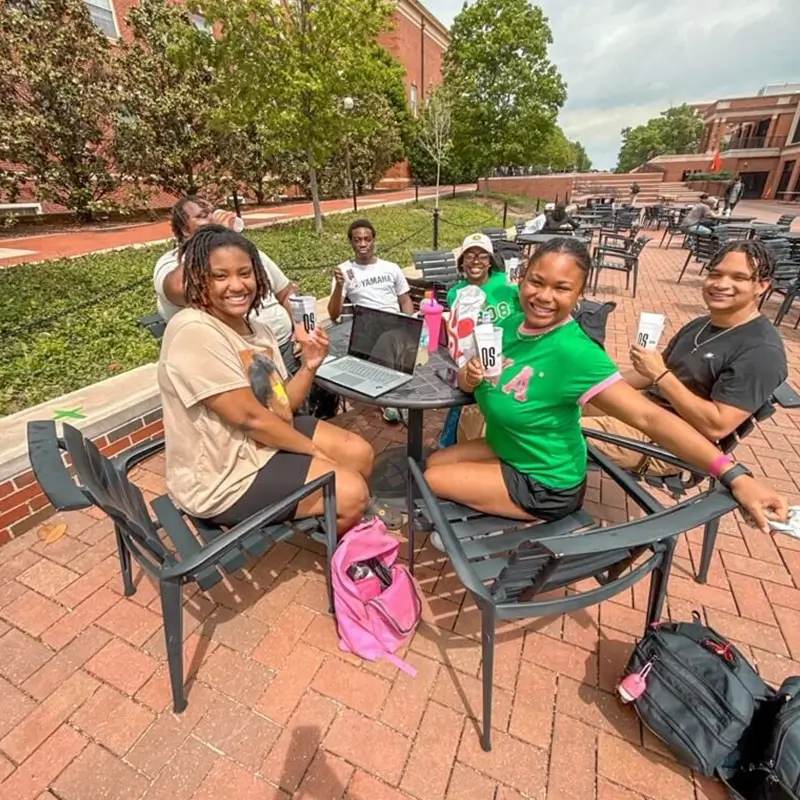 group of young adults studying at an outdoor cafe